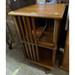 A reproduction mahogany revolving bookcase with slatted dividers and rope-twist supports