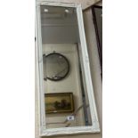 A modern ornate white finish framed bevelled oblong wall mirror