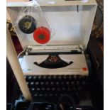 An Olympia Traveller Delux portable typewriter - sold with two WH Smith typewriter ribbons