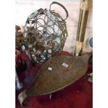 A wrought iron wine rack with applied metal leaf decoration - sold with a similar basket and a metal