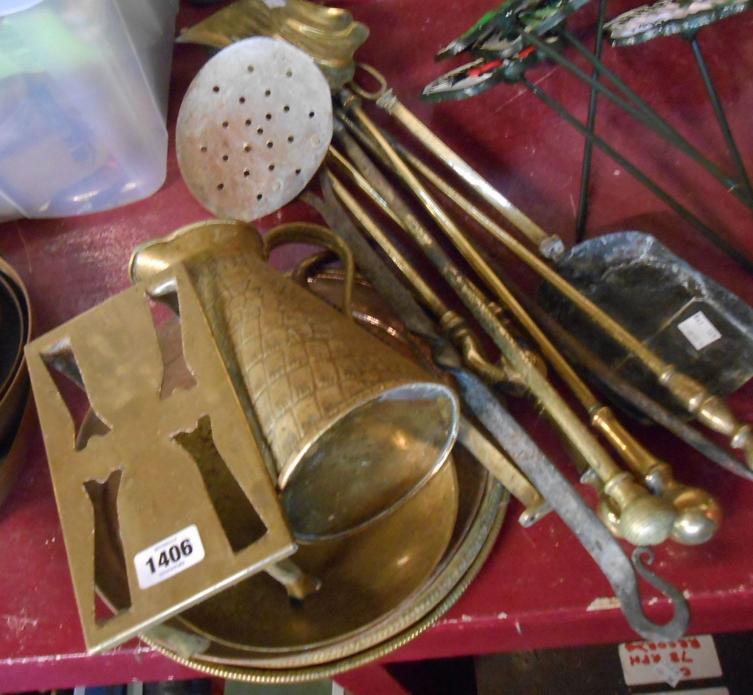 A selection of brass and other metal items including fire dogs, jug, trivet, etc.