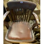 A vintage oak framed office swivel elbow chair with studded upholstered seat panel