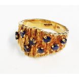 A 9ct. gold bark effect ring with small sapphires