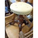 A Victorian rosewood revolving piano stool, set on ornate pillar and tripod base