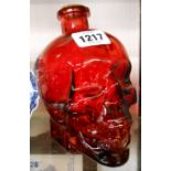 A modern red glass skull pattern bottle with cork stopper