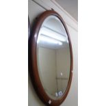An Edwardian walnut framed bevelled oval wall mirror