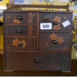A small wooden jewellery box of chest of drawers form with inlaid flowering tree to front