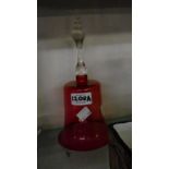 A Victorian cranberry glass bell with applied clear glass handle and original clapper