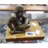 A vintage carved serpentine figure of a seated man on a marble plinth - damage to legs