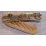A carved bone scrimshaw decorated folding comb with polar bear, sailing ship and kayak scene to