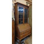 A 91cm early 20th Century oak bureau/bookcase with beaded glazed panel doors over a part fitted