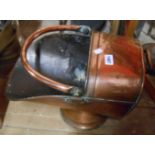 A copper helmet coal scuttle