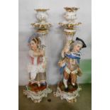 A pair of 19th Century porcelain figural candlesticks depicting a male and female figure in 18th