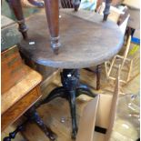 A 58cm diameter old stained wood topped tavern table, set on a painted ornate heavy cast aluminium