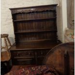 A 1.25m 20th Century stained oak two part dresser in the antique style with two shelf open plate