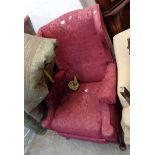 A vintage Parker Knoll reclining wing back armchair upholstered in red floral tapestry, set on