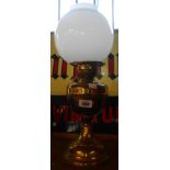 A brass double burner oil lamp with chimney and opaque glass shade