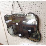 A vintage frameless wall mirror with shaped and faceted plate