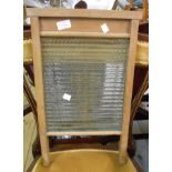 An old ribbed glass and wooden framed washboard