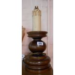A large turned wood table lamp with candle effect sconce