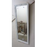 A modern ornate white finish framed bevelled oblong wall mirror