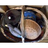 An old wicker basket containing a quantity of assorted items including Bakelite string balls, carved