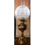 An old brass oil lamp with double burner, chimney and clear and frosted glass shade