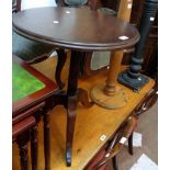 A stained wood pedestal wine table, set on fluted pillar and tripod base