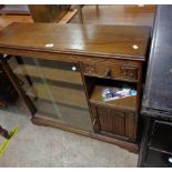 A 92cm vintage oak book cabinet with sliding glass doors, short drawer, cupboard and recess