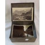 A tin containing a small collection of vintage mainly photographic postcards