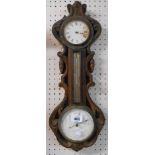 A late Victorian carved oak cased combined wall barometer and timepiece with eight day movement,