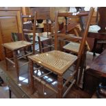 A pair of Edwardian stained wood framed standard chairs with rattan seat panels, set on turned front