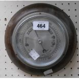 A vintage oak cased aneroid wall barometer with printed silvered effect dial