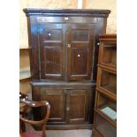 A 1.15m antique oak corner cabinet with remains of dentil cornice, canted sides and painted