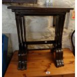 A nest of three reproduction mahogany tea tables with decorative pierced standard ends - wear