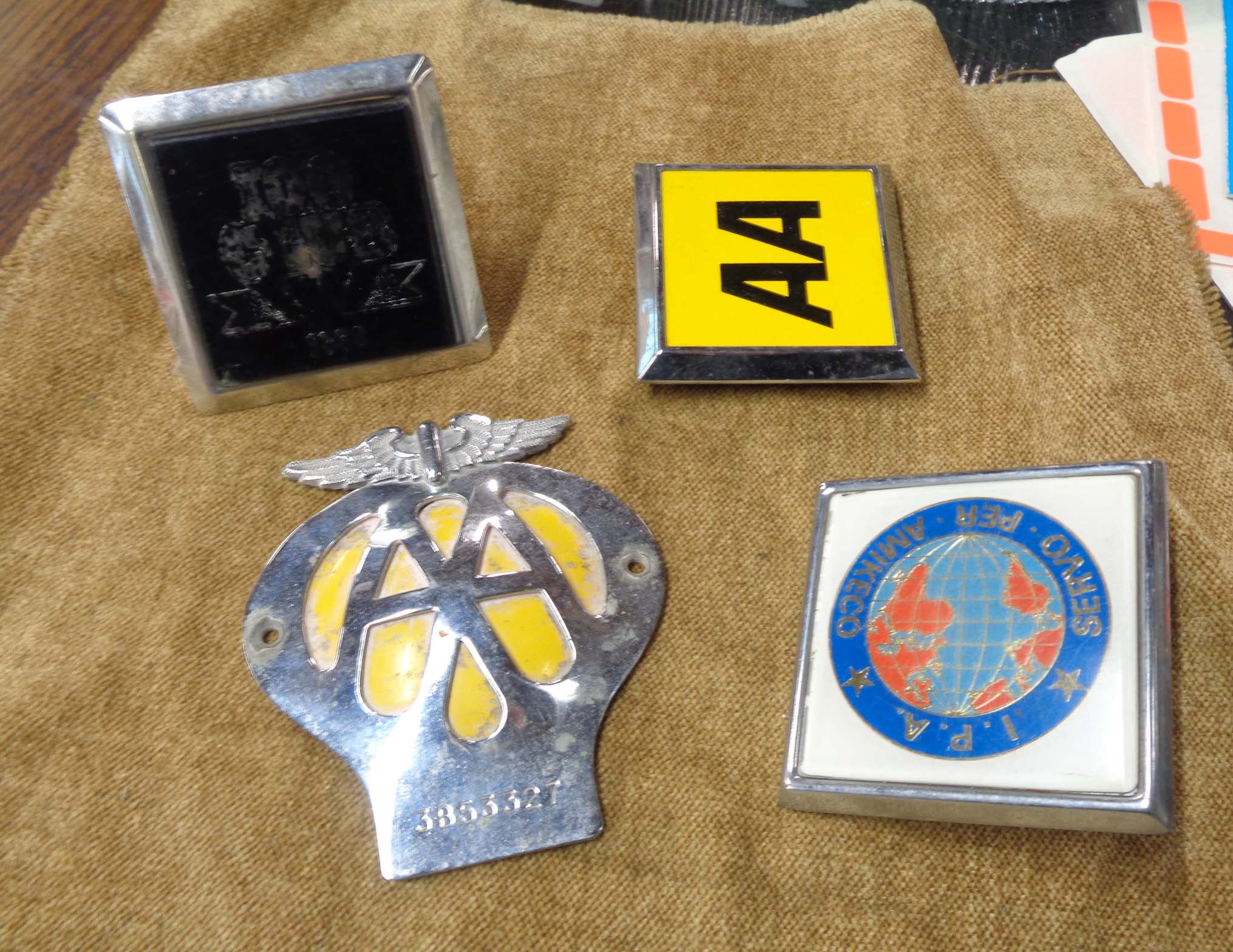 Four vintage car badges including two AA, one IPA, etc.