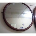 A stained walnut framed circular wall mirror - from a dressing table