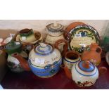 A quantity of Torquay pottery including large teapot, Watcombe cottage decorated jug, etc.