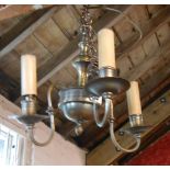 An old brass electric ceiling lamp of three branch candelabra form
