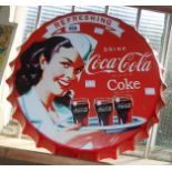 A reproduction printed tin bottle top form Coca-Cola sign