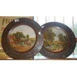 A pair of early 20th Century pressed tin decorative wall plaques with central litho printed scene