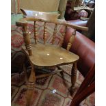 An antique smoker's bow elbow chair with solid moulded elm seat, set on ring turned supports