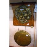 An early 20th Century wall mounted dinner gong with large brass lion mask on oak panel and beater