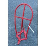 A metal wall hanging saddle stand with red plasticote finish