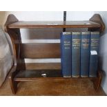 A vintage polished oak book stand containing four Dickens vols