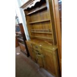 A 1.3m 20th Century polished oak two part dresser with four shelf open plate rack over a base with
