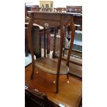 An Edwardian polished oak two tier occasional table, set on slender cabriole supports