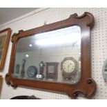 A 20th Century oak framed mirror bevelled wall mirror with decorative C-scroll corners and rounded