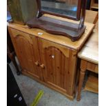 An 80cm modern pine cupboard enclosed by a pair of panelled doors, set on bracket base