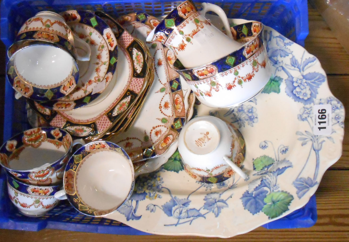 A small crate containing an Imari pattern part tea set and transfer printed meat plate